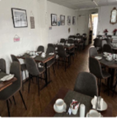 A breakfast table laid with white linen in the dining room